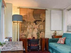 a living room with a painting on the wall at Burwood Cottage in Rotherfield Peppard