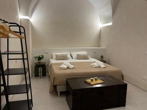 a bedroom with a bed with a table and a ladder at Casa Petra - Santa Croce in Lecce