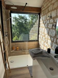 a bathroom with a large window and a sink at Le clos des Oiseaux in Itzac