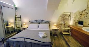 a bedroom with a bed and a bathroom with a tub at Suite Grotta della luna in Ostuni