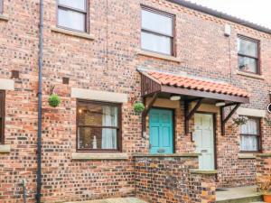 a brick house with a blue door at Whitby Sands in Whitby