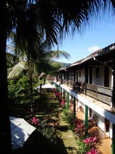 a resort with a palm tree and a building at Pousada do Tesouro in Paraty
