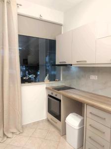 Una cocina con gabinetes blancos y encimera. en Galazio suites 2, en Salamina