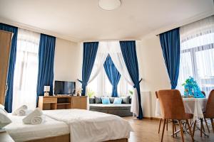 a bedroom with two beds and a living room with a christmas tree at Hotel Port Altus in Batumi