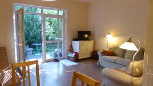 sala de estar con sofá y puerta corredera de cristal en Family Cottage, en Gárdony