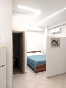 Un dormitorio con una cama en una habitación blanca. en Galazio suites 2, en Salamina