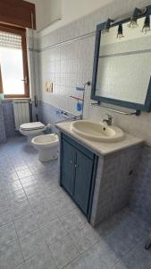 un bagno con lavandino, WC e specchio di Elettra House Anzio ad Anzio Altre 11 foto