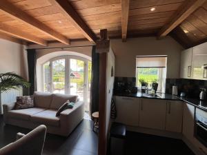 a kitchen and living room with a couch and a table at Vakantiewoning 't Veldzicht in Rossum