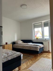 a bedroom with two beds and a window at Home Nikolić in Novi Pazar