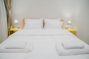 a white bed with white sheets and pillows at Ground Floor Gem - Patio Lounge in Cairo