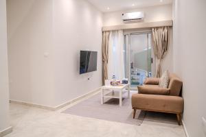 a living room with a chair and a television at Ground Floor Gem - Patio Lounge in Cairo