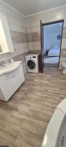 a bathroom with a sink and a washing machine at Casa Coresi in Braşov