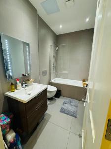 a bathroom with a sink and a toilet and a tub at Bernard Street Edinburgh Apartment in Edinburgh +24 photos