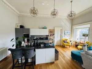 a kitchen with a table and chairs in a living room at Bernard Street Edinburgh Apartment in Edinburgh