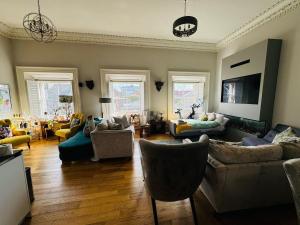 a living room with couches and chairs and a tv at Bernard Street Edinburgh Apartment in Edinburgh