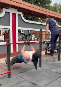 a man is in a barbell in a gym at STARS University Dormitory in Tashkent