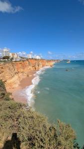 a view of a beach with the ocean and buildings at Praia da Rocha Apartamento Costa Azul in Portimão