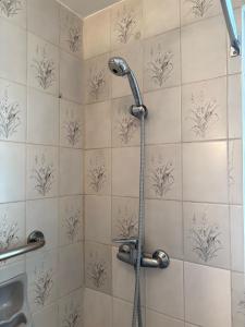 a shower with a hose in a bathroom at Apartamento con hermosa vista y soleado en Sopocachi in La Paz