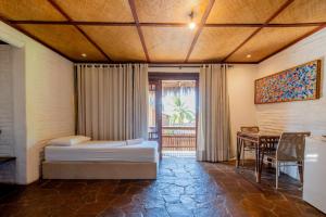 a bedroom with two beds and a table and a window at Dayo Hotel in Flecheiras +84 photos
