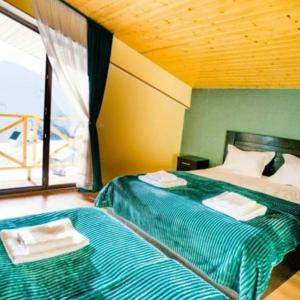 a bedroom with two beds with towels on them at Sunny Hill Gudauri in Gudauri
