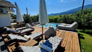 a wooden deck with couches and a swimming pool at СПА къща за гости Каза Роза - Swiss Style Chalet Casa Rosa SPA Guest House in Kyustendil