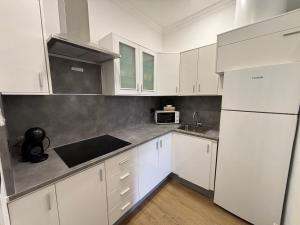 a kitchen with white cabinets and a white refrigerator at VV LAS ARENAS Apartamento Reformado en Puerto de la Cruz in Puerto de la Cruz