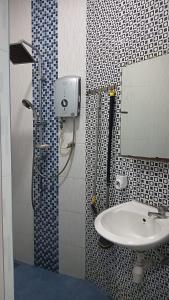 a bathroom with a sink and a shower with a mirror at Dang anum homestay in Segamat
