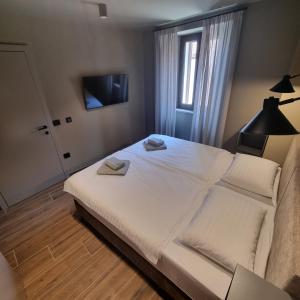 a bedroom with a large white bed with a window at Old Town Vrsar Premium Apartments in Vrsar