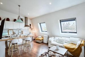 a living room with a white couch and a kitchen at Hôtel-particulier - T2 - lumineux in La Madeleine