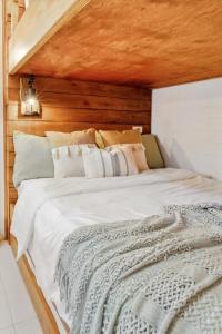 a bedroom with a large white bed with a wooden wall at CABIN STUDIO in KL TOWER, Greenbelt, Makati! Max Capacity 6 pax! in Manila