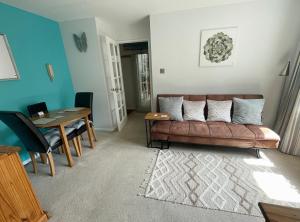 a living room with a couch and a table at Beautiful Peaceful Studio Flat in Waltham Abbey