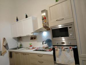 a kitchen with a stove and a microwave at La casa di Dea in Marsala +25 photos
