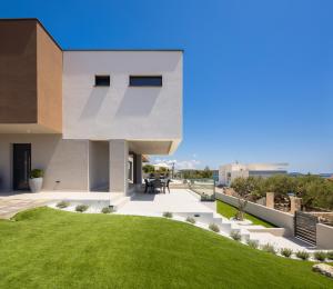 a modern house with a green lawn at Villa Svetog Vida in Sevid