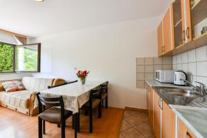 a kitchen and living room with a table and chairs at House Jole in Drežnik Grad