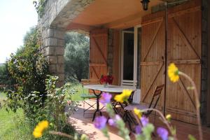 a patio with a table and chairs and flowers at Maquis et plage in Sollacaro