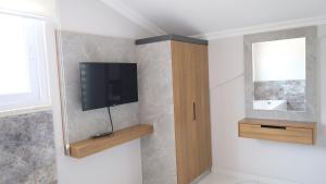 a bathroom with a flat screen tv on a wall at Yaz Villa in Fethiye