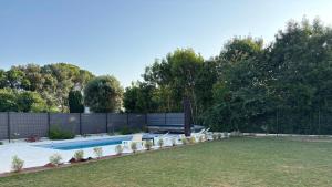 a backyard with a swimming pool and a fence at Le Bonheur de l'Instant in Saint-Médard-dʼAunis