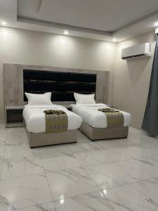 two beds in a hotel room with two bedsvisor at Afdal Rehla Serviced Apartments in Jazan +40 photos