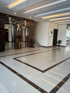 a lobby with a marble floor in a building at Afdal Rehla Serviced Apartments in Jazan