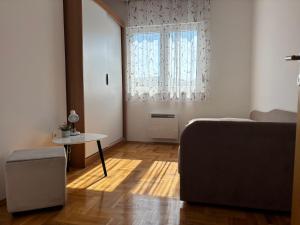 a bedroom with a bed and a table and a window at Cozy corner Mostar in Mostar