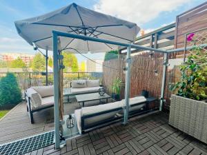 a patio with two beds under an umbrella at Apartament z ogródkiem, blisko centrum in Zielona Góra