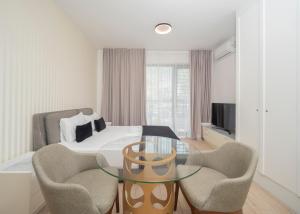 a bedroom with a bed and a glass table and chairs at CASA AL MARE RESIDENCE in Bečići