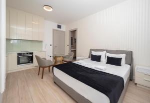 a bedroom with a large bed and a kitchen at CASA AL MARE RESIDENCE in Bečići