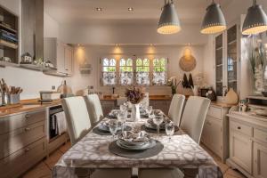 a kitchen with a dining room table and chairs at Garden Village Residence in Kalamaki