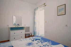 a small bedroom with a bed and a dresser at Apartment Kamenar 3 in Klimno
