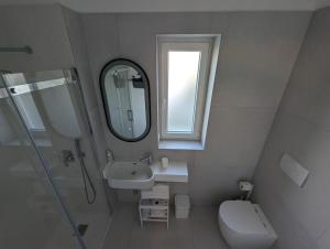 a bathroom with a sink and a mirror and a toilet at 73059 Versilia in Fontanelle +10 photos