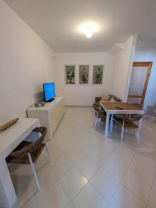 a living room with a table and a desk with a laptop at 73059 Versilia in Fontanelle