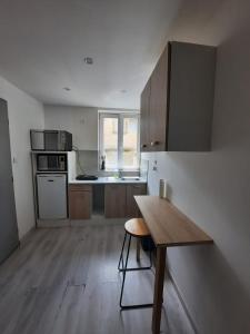 a kitchen with a wooden table and a wooden floor at Appartement équipé in Saint-Julien-Molin-Molette