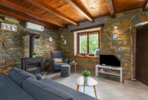 a living room with a blue couch and a stone wall at Vila Deja in Marušići