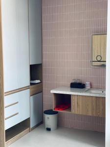 a bathroom with a counter and a pink tiled wall at Homestay 1986 & Homestay Vinhomes Vu Yen, Hai Phong City 